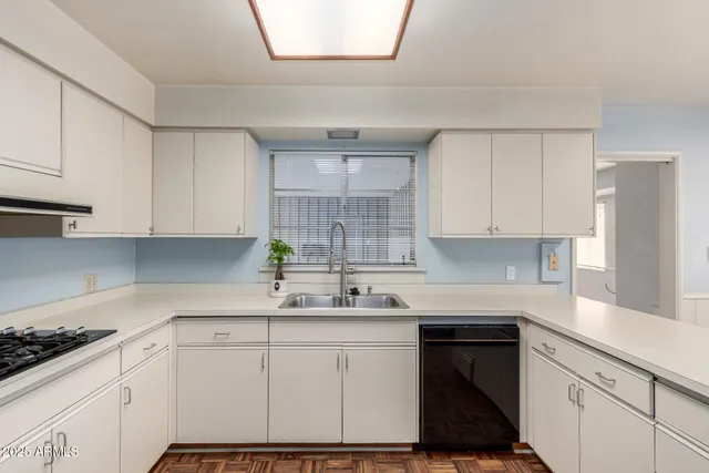 a kitchen with granite countertop a sink stove and cabinets