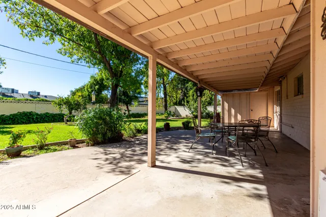 a view of house with backyard and trees in the background