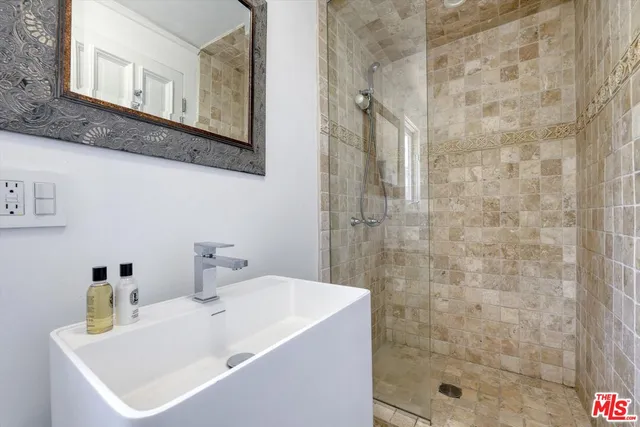 a bathroom with a sink a mirror and shower