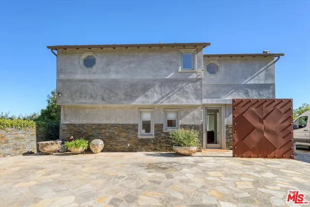 a view of a brick house with potted plants in front of it