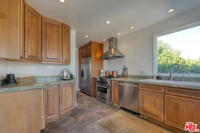 a kitchen with stainless steel appliances granite countertop a sink and stove top oven