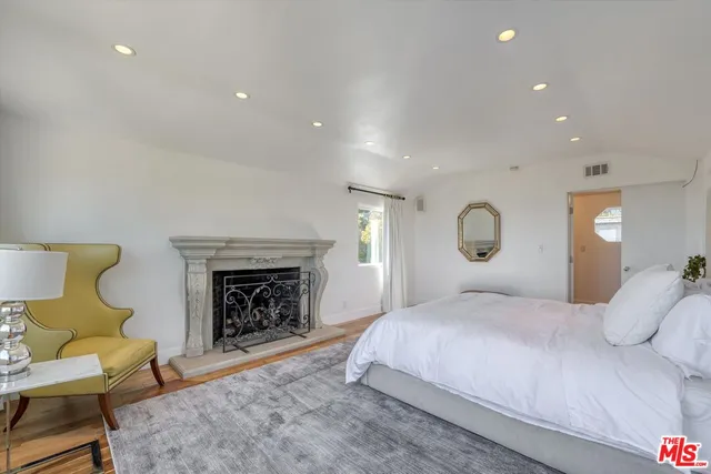 a bedroom with a large bed and a fireplace