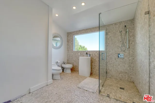 a bathroom with a shower a toilet and a sink