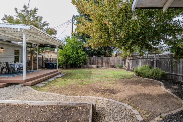 a view of a patio with table and chairs with wooden floor and fence