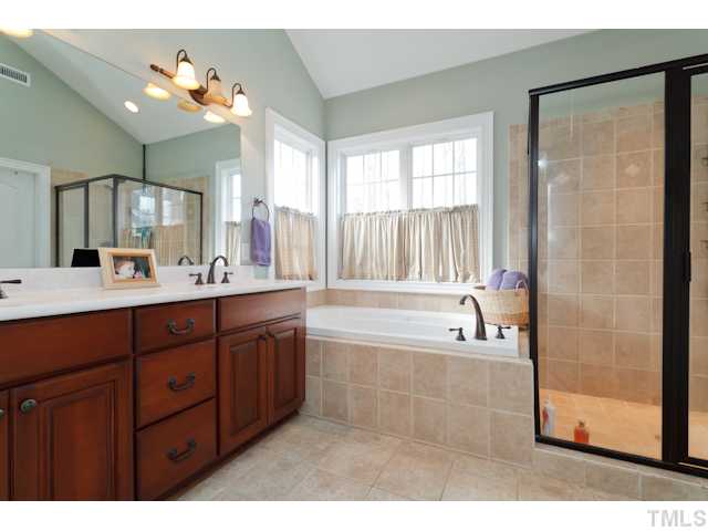 4216 Oakthorne Way Raleigh, NC 27613 - Photo 14 of 24 a spacious bathroom with a tub double sink shower and mirror
