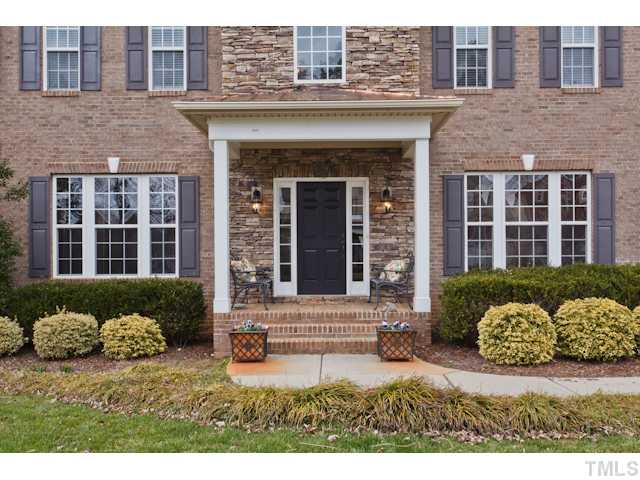 4216 Oakthorne Way Raleigh, NC 27613 - Photo 24 of 24 a view of a brick house with large windows and a yard
