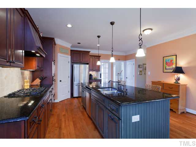 4216 Oakthorne Way Raleigh, NC 27613 - Photo 10 of 24 a kitchen with stainless steel appliances granite countertop a stove a sink a refrigerator and a wooden cabinets