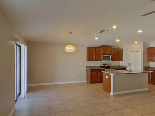 a kitchen with stainless steel appliances granite countertop a stove top oven a sink and a refrigerator