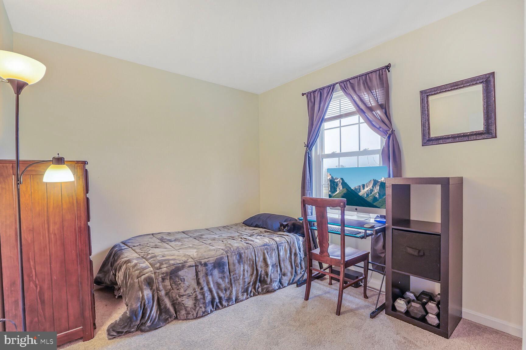 7810 Gateshead Lane Manassas, VA 20109 - Photo 16 of 20 a bedroom with a bed and a lamp next to a window