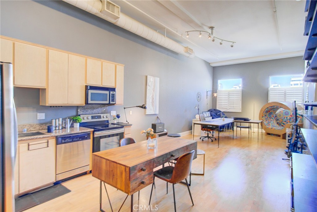 175 S Lake, Unit 402 Pasadena, CA 91101 - Photo 1 of 1 a open kitchen with stainless steel appliances kitchen island granite countertop a stove a sink a dining table and chairs with wooden floor