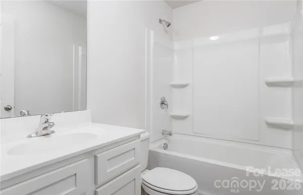a bathroom with a sink toilet vanity and shower