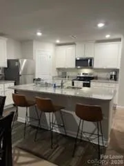 a kitchen with a dining table chairs microwave and cabinets