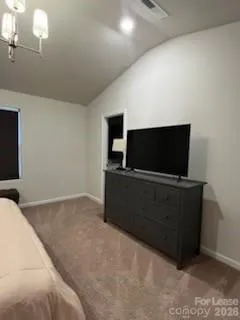 a living room with a flat screen tv on dresser and a bookshelf