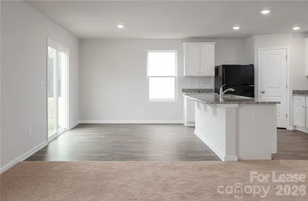 an empty room with a flat screen tv and windows