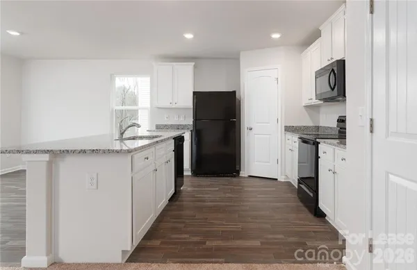 a kitchen with stainless steel appliances granite countertop a refrigerator and a stove