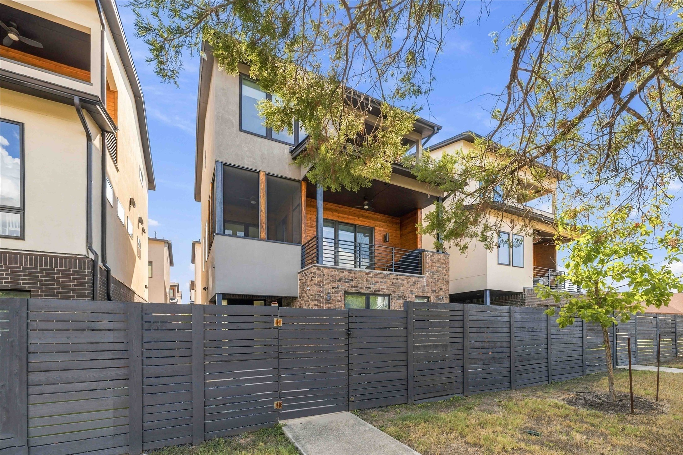 5006 Pecan Springs Road, Unit 7 Austin, TX 78723 - Photo 32 of 38 Modern multi-level exterior architecture features rich brick accents, wood cladding, and a secure fenced yard.