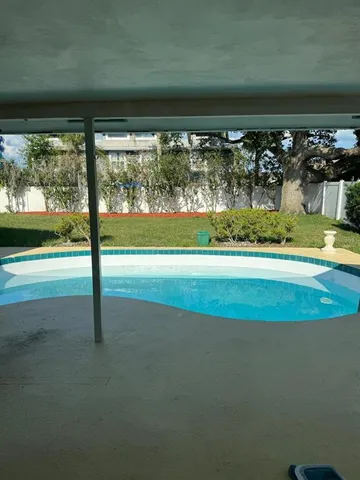 a view of a living room and floor to ceiling window and an outdoor kitchen