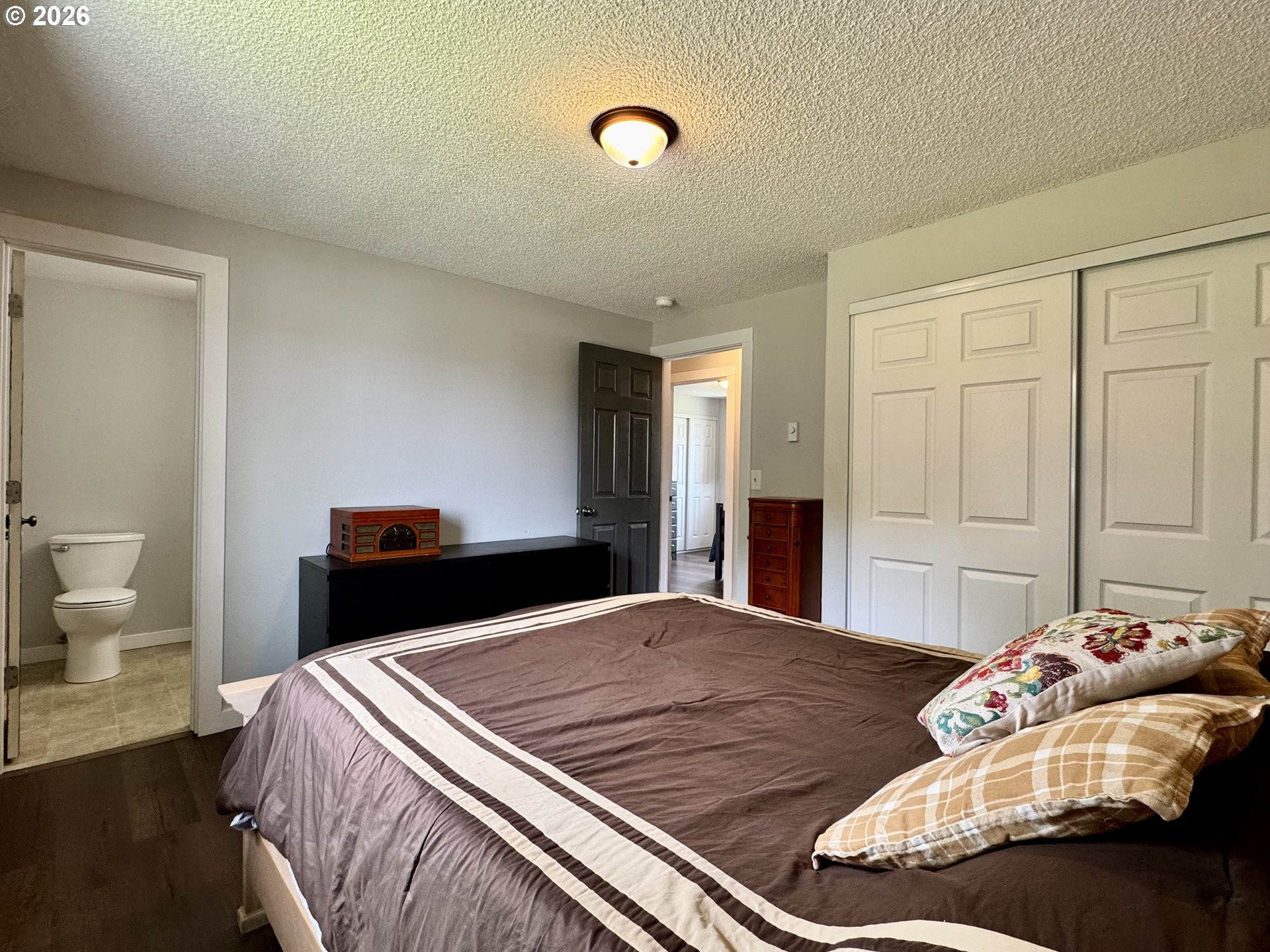 420 Juniper Street Florence, OR 97439 - Photo 25 of 34 a bedroom with a bed and a lamp