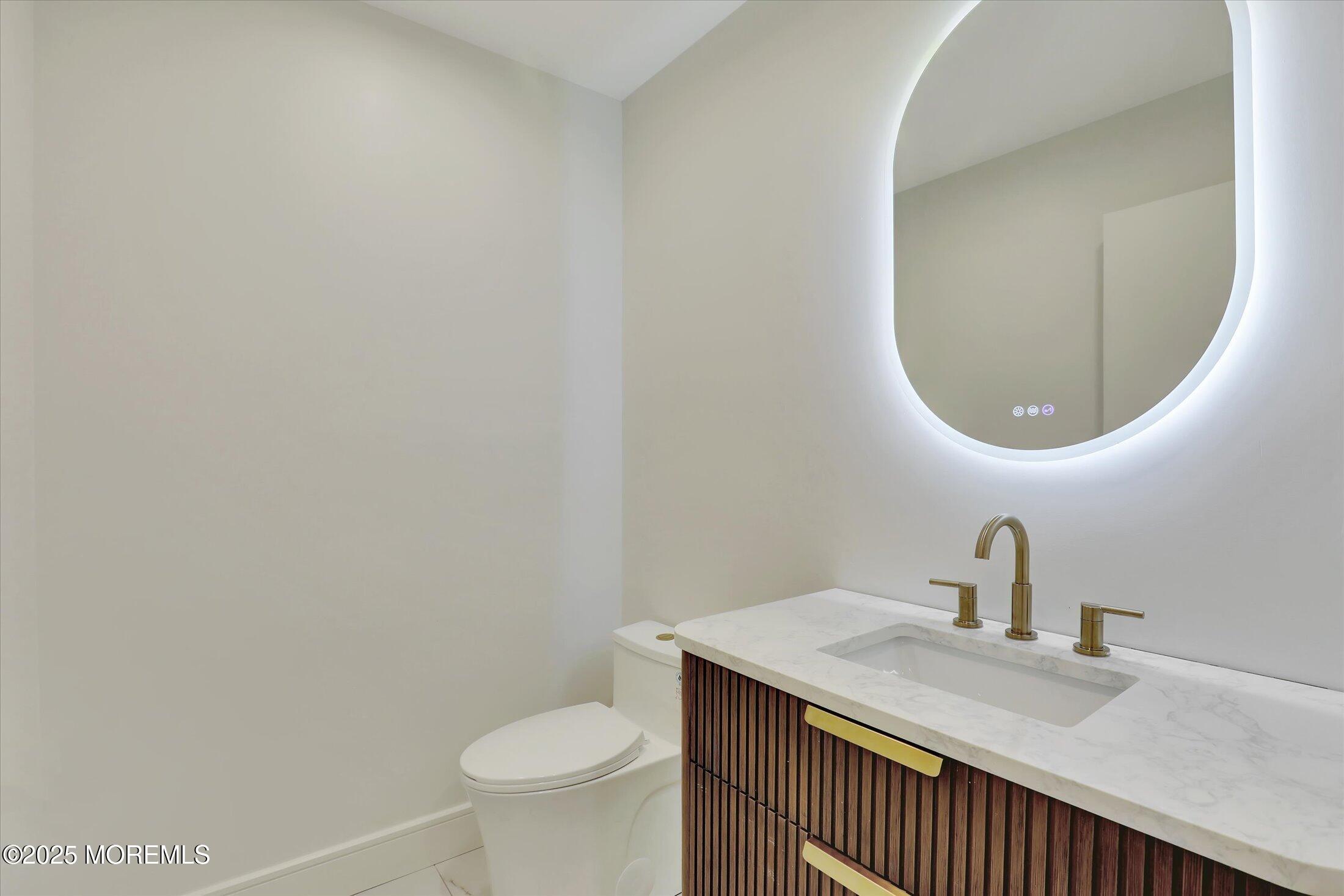 243 Woodcrest Road Oakhurst, NJ 07755 - Photo 17 of 42 a bathroom with a sink and a mirror