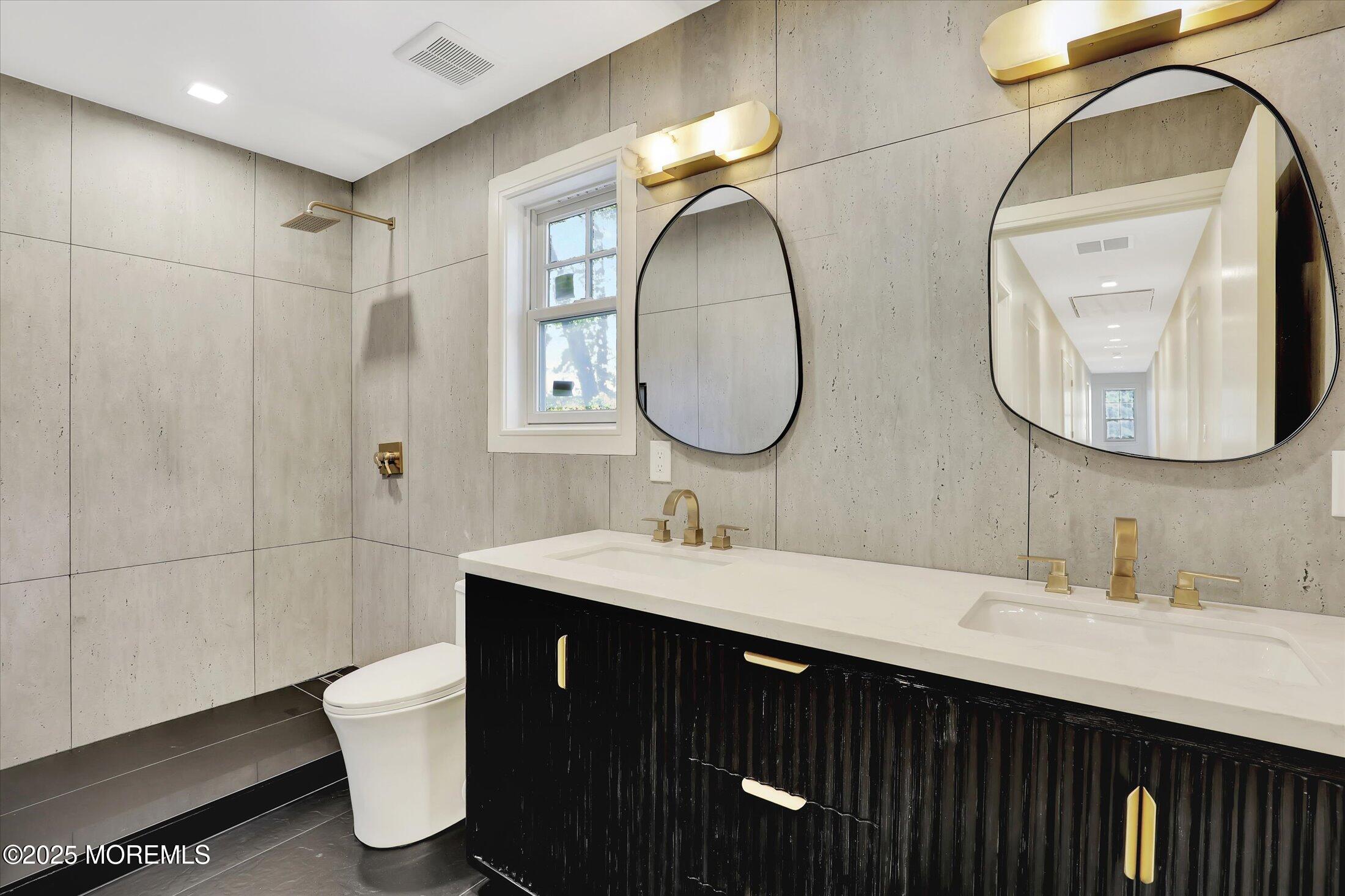 243 Woodcrest Road Oakhurst, NJ 07755 - Photo 28 of 42 a bathroom with a double vanity sink and a mirror