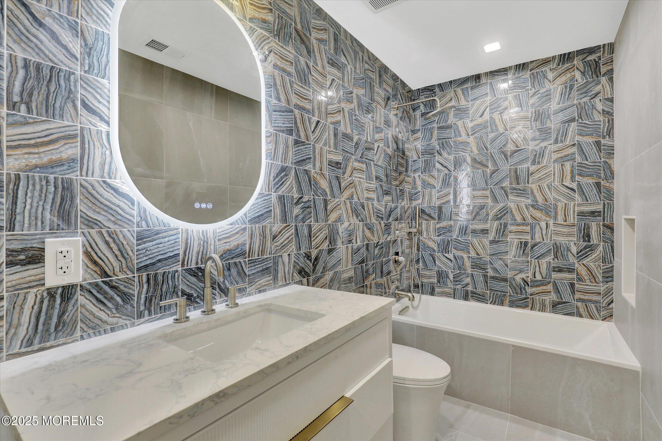 243 Woodcrest Road Oakhurst, NJ 07755 - Photo 31 of 42 a bathroom with a sink a toilet and a mirror