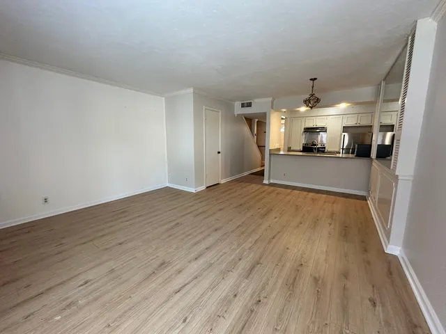 a view of a living room hardwood floor and a kitchen