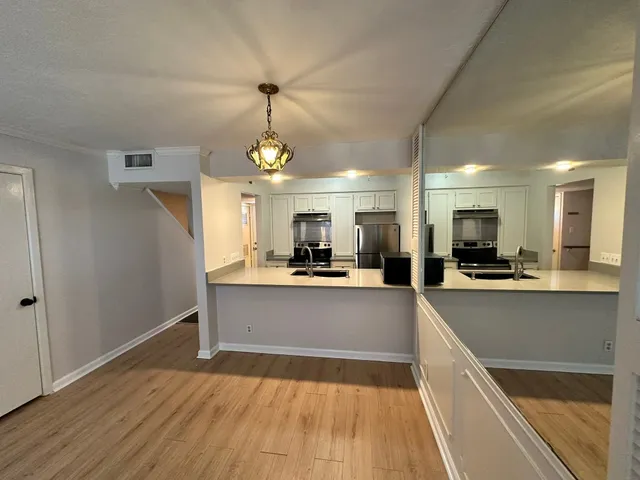 a large kitchen with cabinets and wooden floor