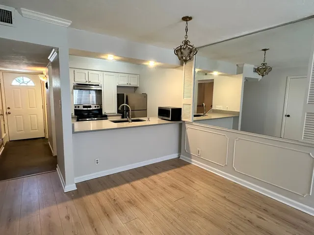a kitchen with a refrigerator cabinets and wooden floor