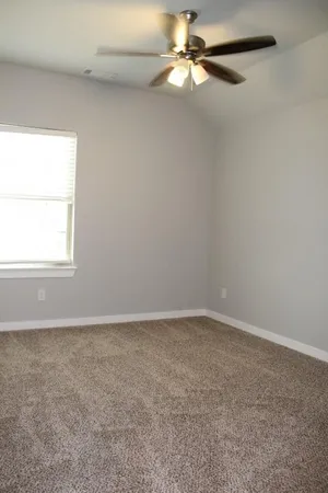 an empty room with a window and a fan