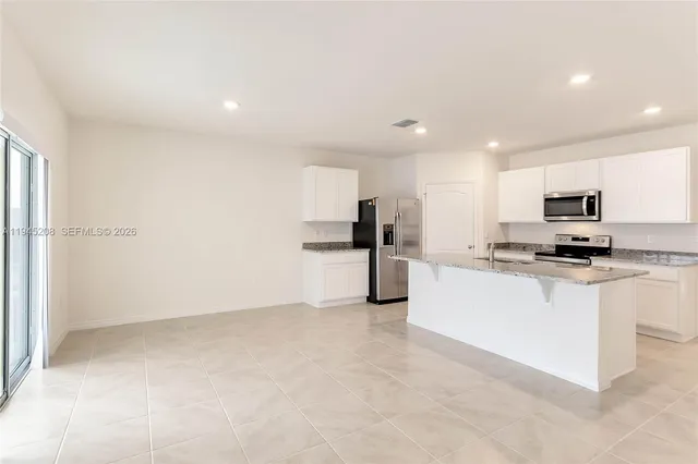 a kitchen with stainless steel appliances a refrigerator sink stove microwave and cabinets