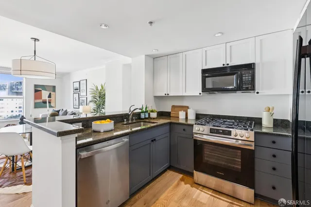 a kitchen with stainless steel appliances a stove sink microwave and cabinets