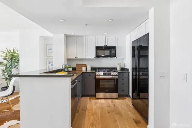 a kitchen with stainless steel appliances granite countertop a stove a sink and a refrigerator