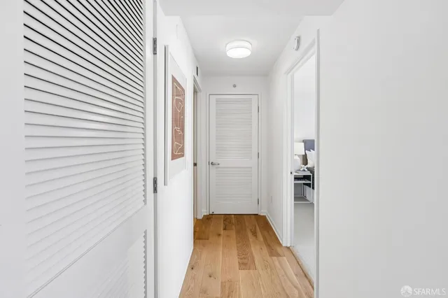 a view of a hallway with wooden floor and staircase