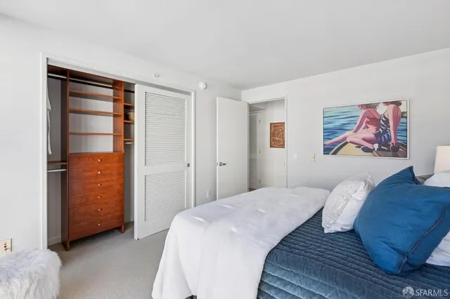 a bedroom with a bed and a painting on the wall