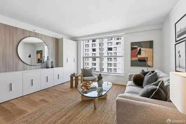 a living room with furniture a window and a wooden floor
