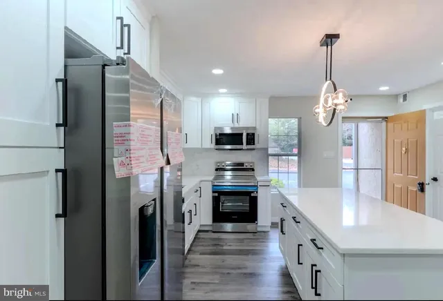 a kitchen with kitchen island a sink stainless steel appliances and cabinets