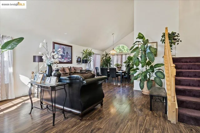 a living room with furniture a potted plant and a table