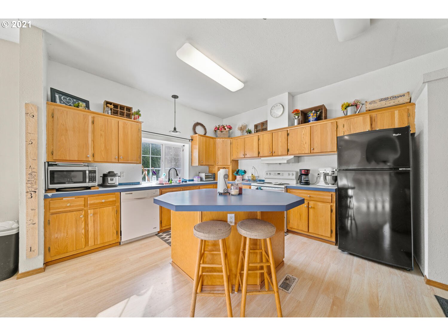 15639 South Fawn View Way Molalla, OR 97038 - Photo 3 of 11 a kitchen with stainless steel appliances kitchen island granite countertop a refrigerator a sink and white cabinets