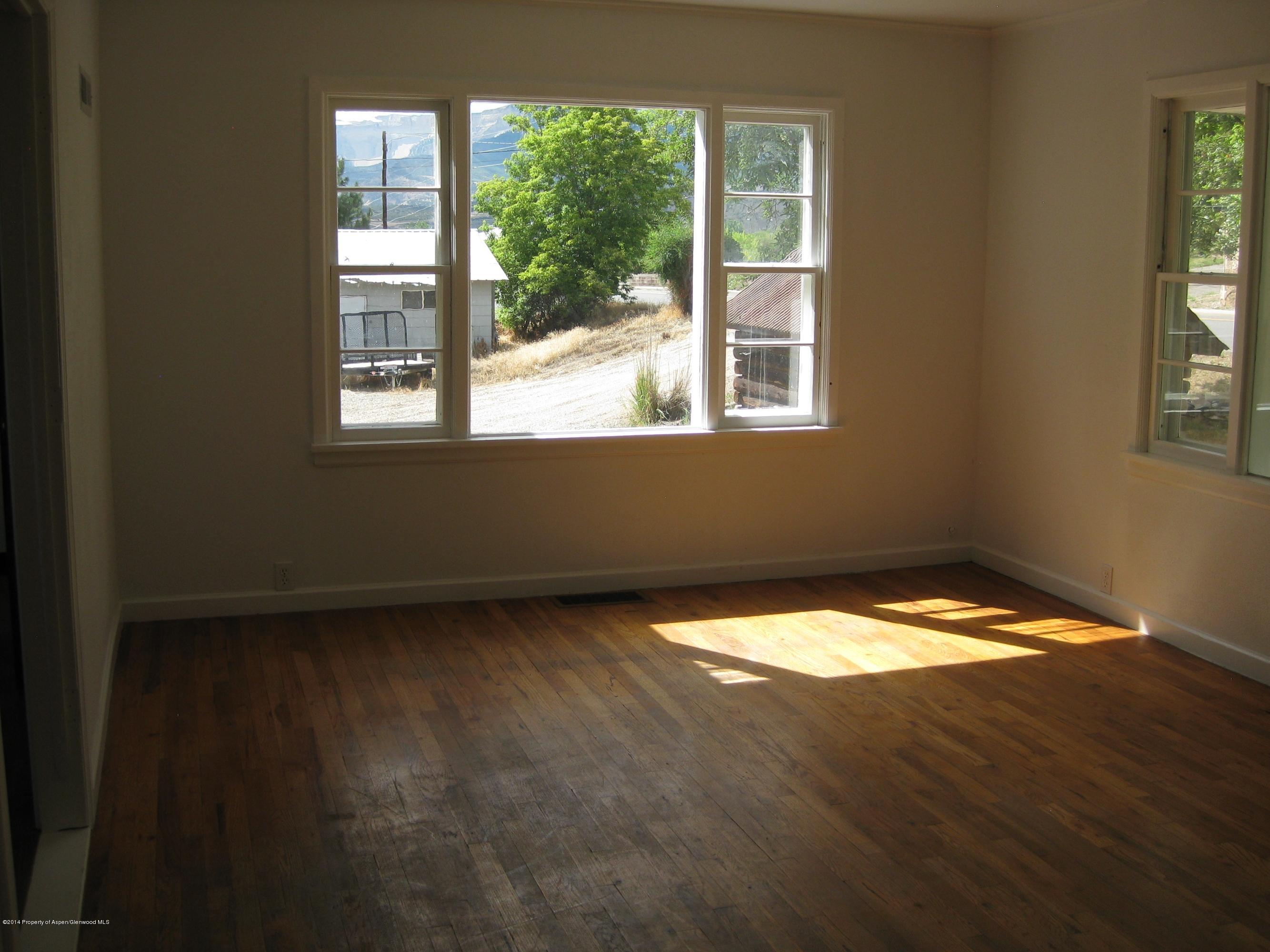 653 East 7th Street Rifle, CO 81650 - Photo 4 of 16 a view of an empty room with wooden floor and a window