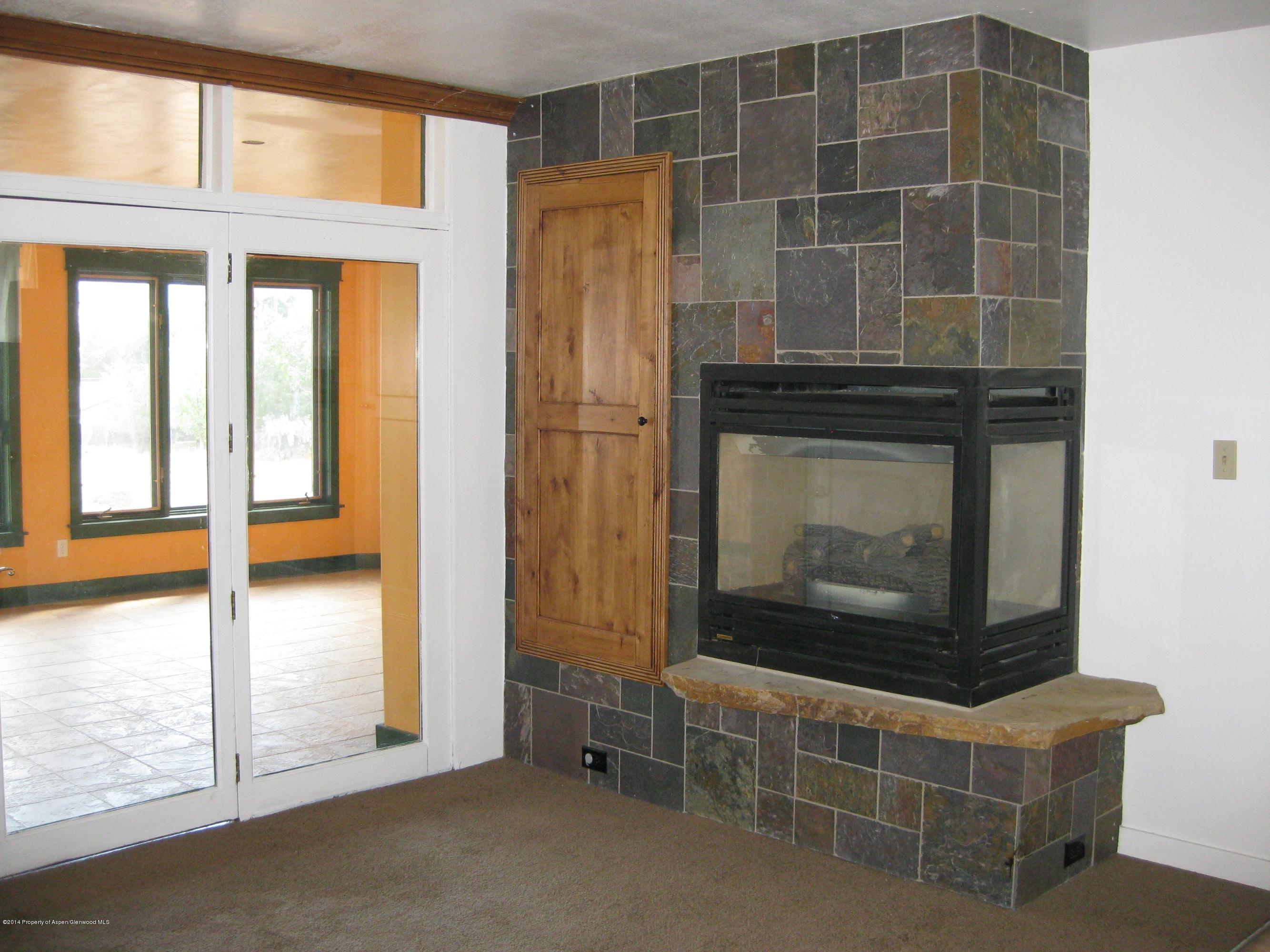 653 East 7th Street Rifle, CO 81650 - Photo 9 of 16 a living room with furniture windows and a fireplace