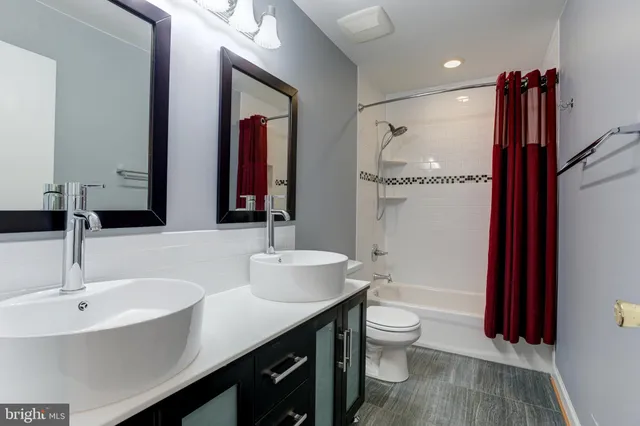 a bathroom with a double vanity sink and a toilet