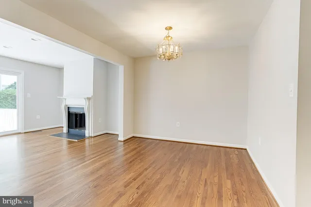 a view of a livingroom with wooden floor and a fireplace