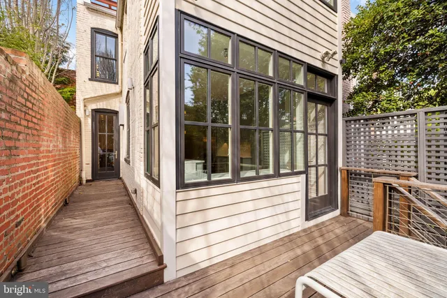 a view of a patio with couches and a fire pit and wooden fence