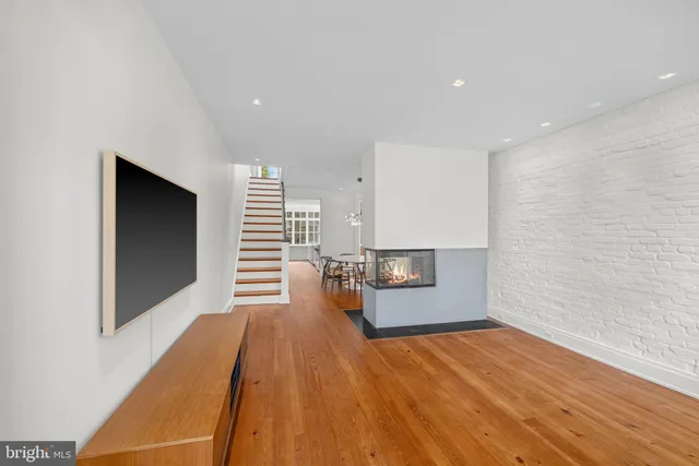 a view of a living room with wooden floor and large window