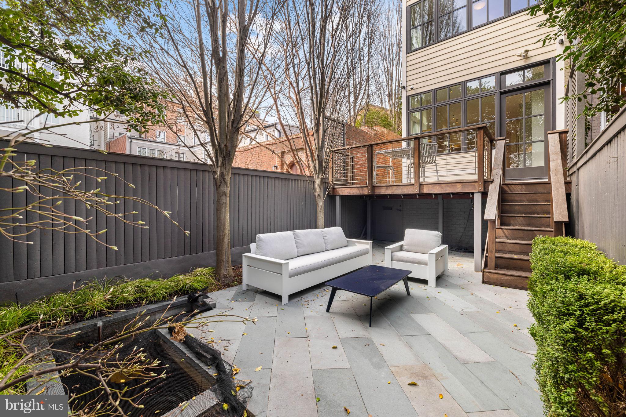 2912 Dumbarton Street Northwest Washington, DC 20007 - Photo 21 of 22 a view of a patio with couches and a fire pit and wooden fence