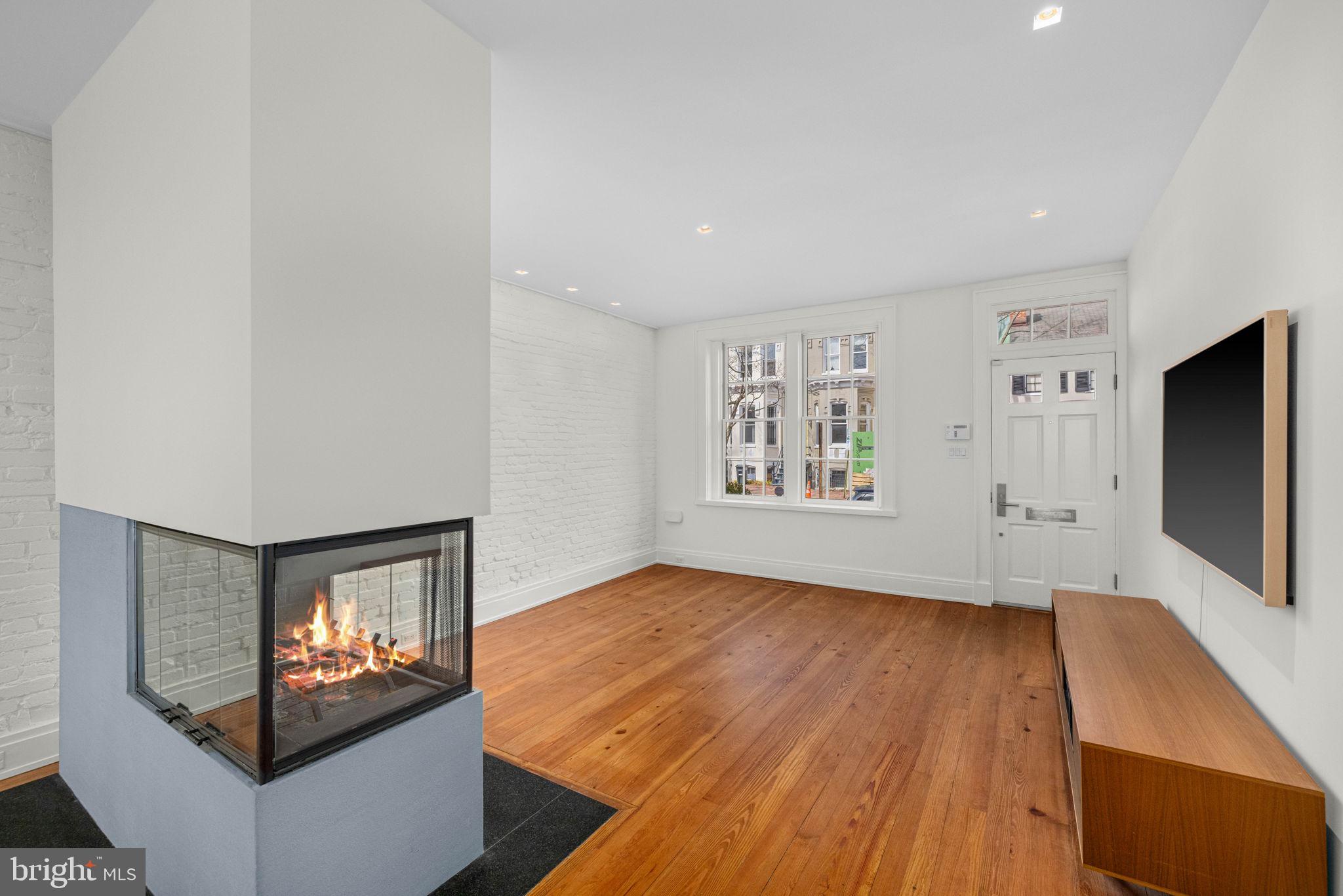 2912 Dumbarton Street Northwest Washington, DC 20007 - Photo 3 of 22 a view of a living room with wooden floor and large window