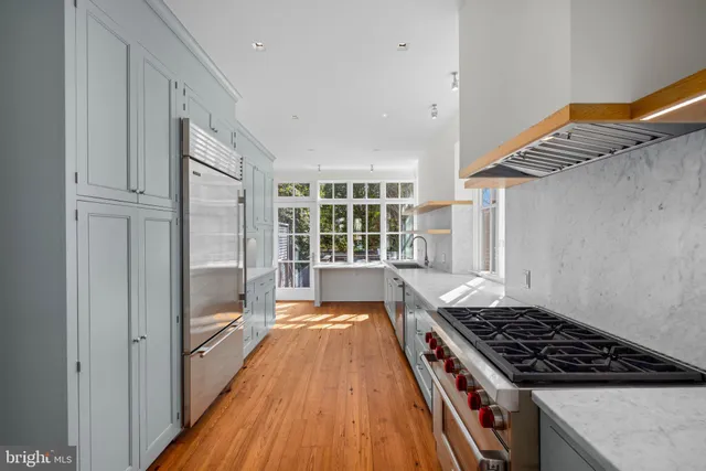 a large kitchen with a lot of counter space and wooden floor