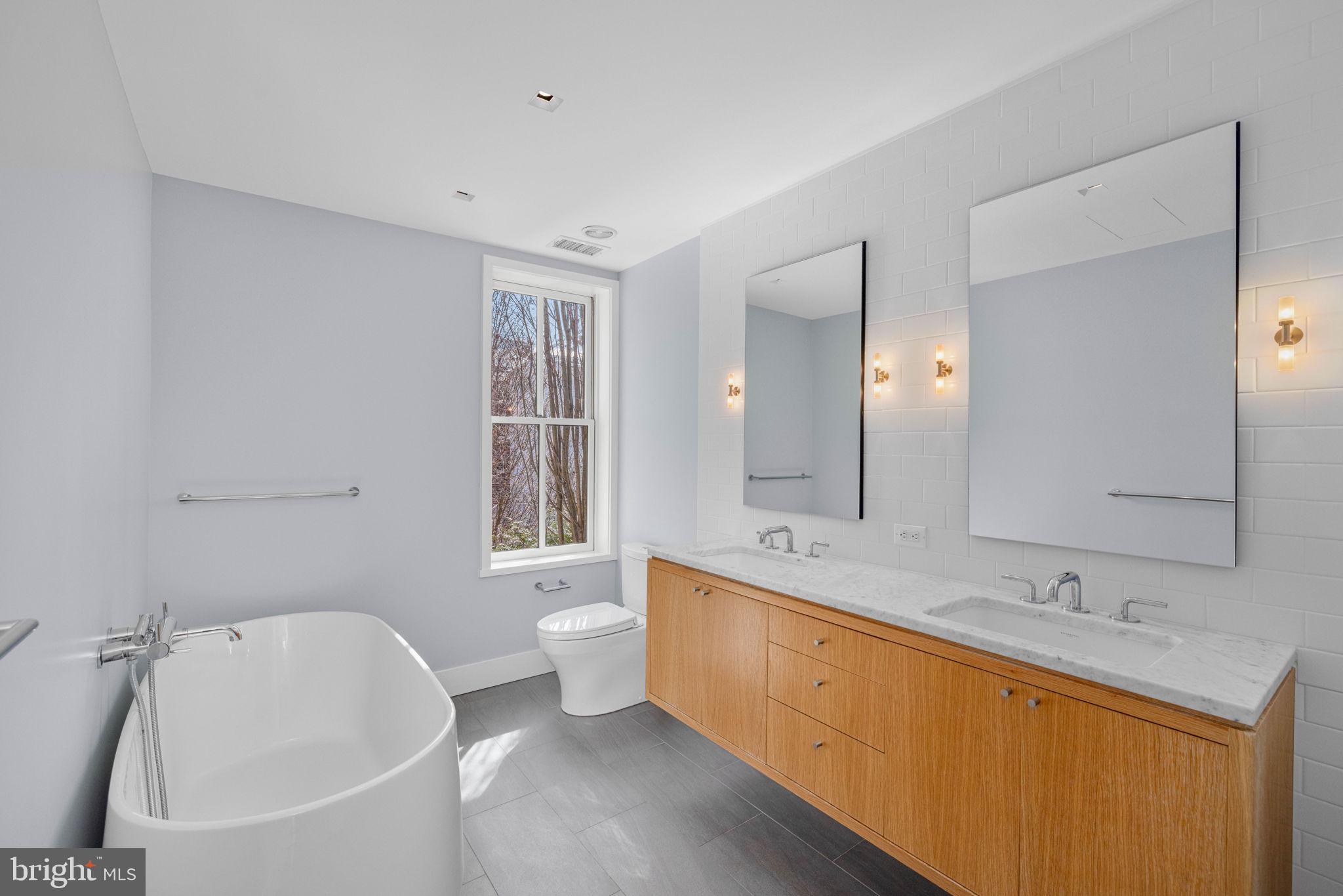 2912 Dumbarton Street Northwest Washington, DC 20007 - Photo 10 of 22 a spacious bathroom with a tub sink and mirror