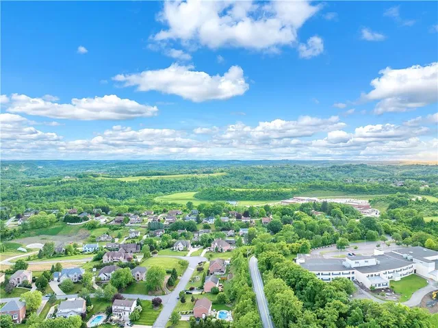 a view of a city with lush green forest