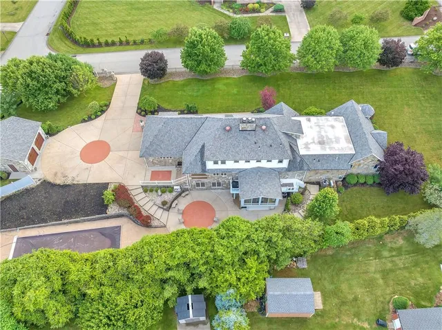 an aerial view of a house with a garden and lake view